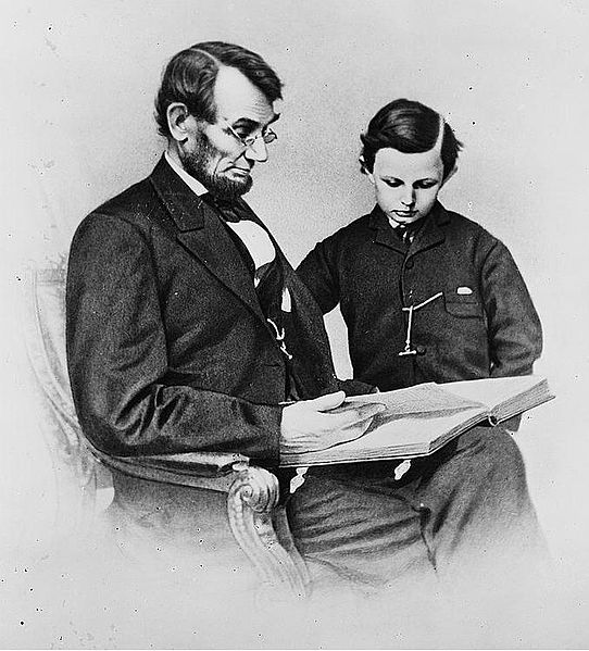Abraham Lincoln and his son Tad looking at an album of photographs