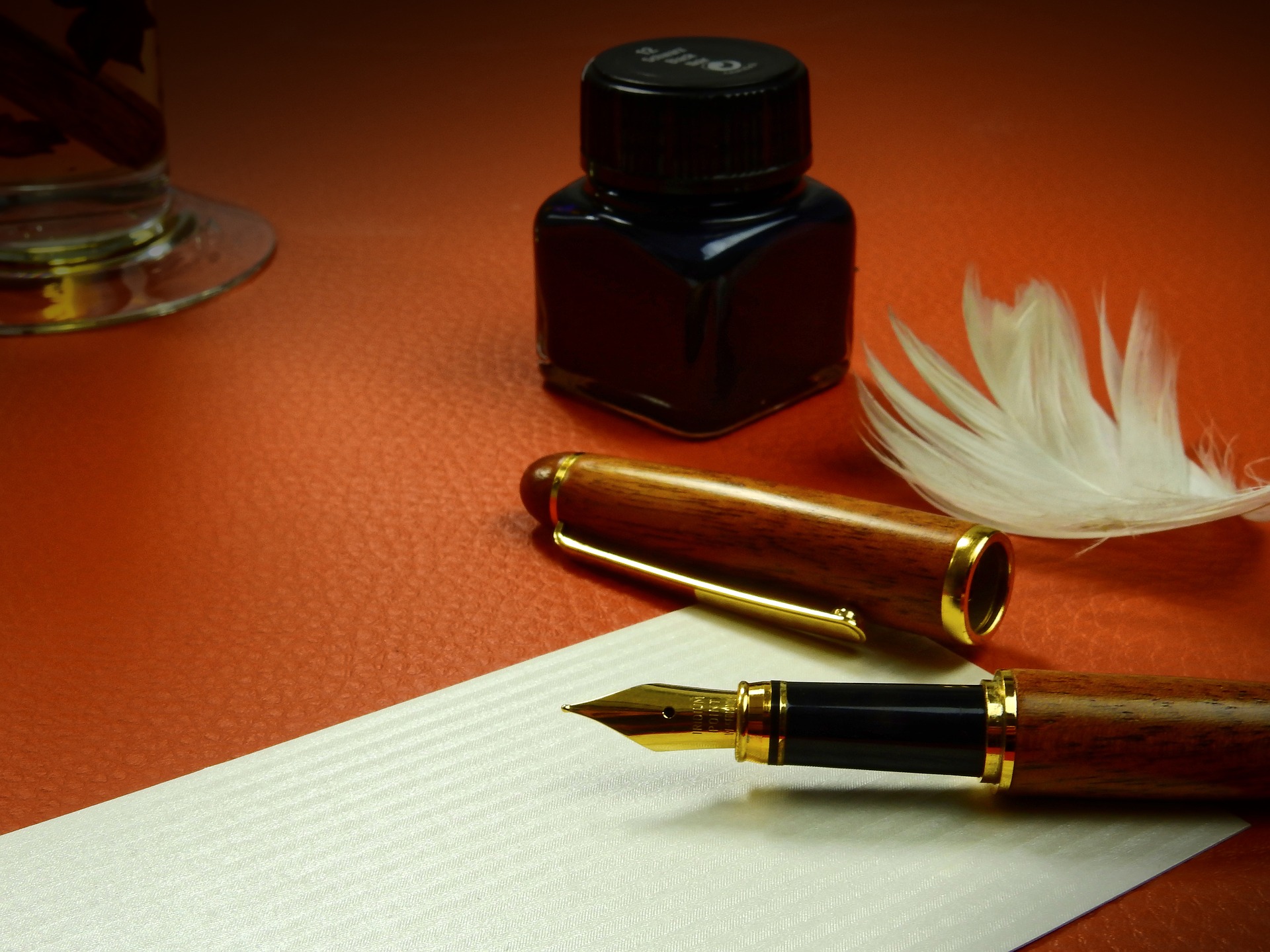 classic ink pen, liquid ink in jar, writing paper, feather, Idris Elba quote,